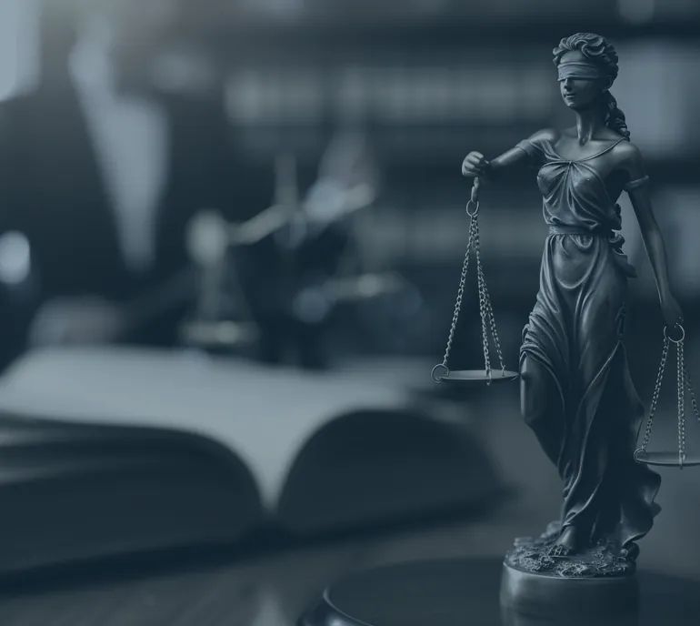 Statue of Lady Justice beside an open law book